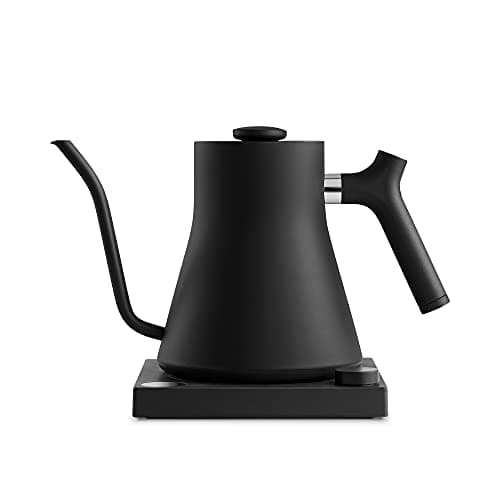A matte black Fellow Stagg EKG gooseneck kettle with a to-the-degree temperature dial on its base.